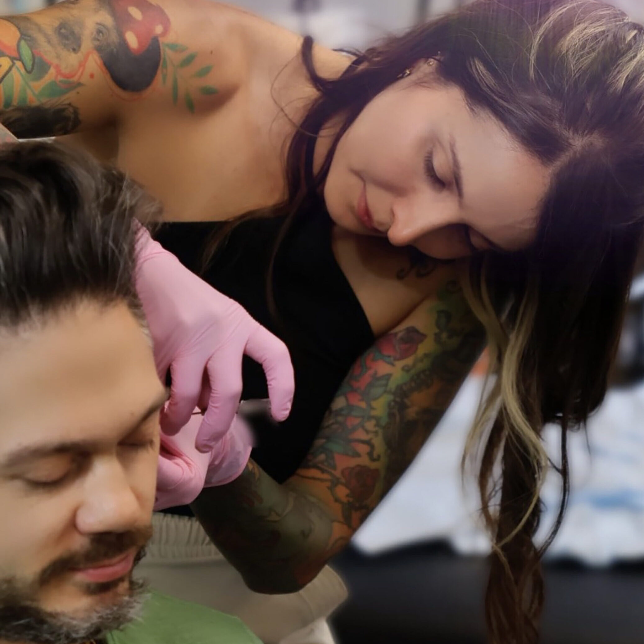 Natalie LaPiercer piercing the ear of jazz musician Nick Biello with titanium jewelry in the Manhattan studio. Nyc.