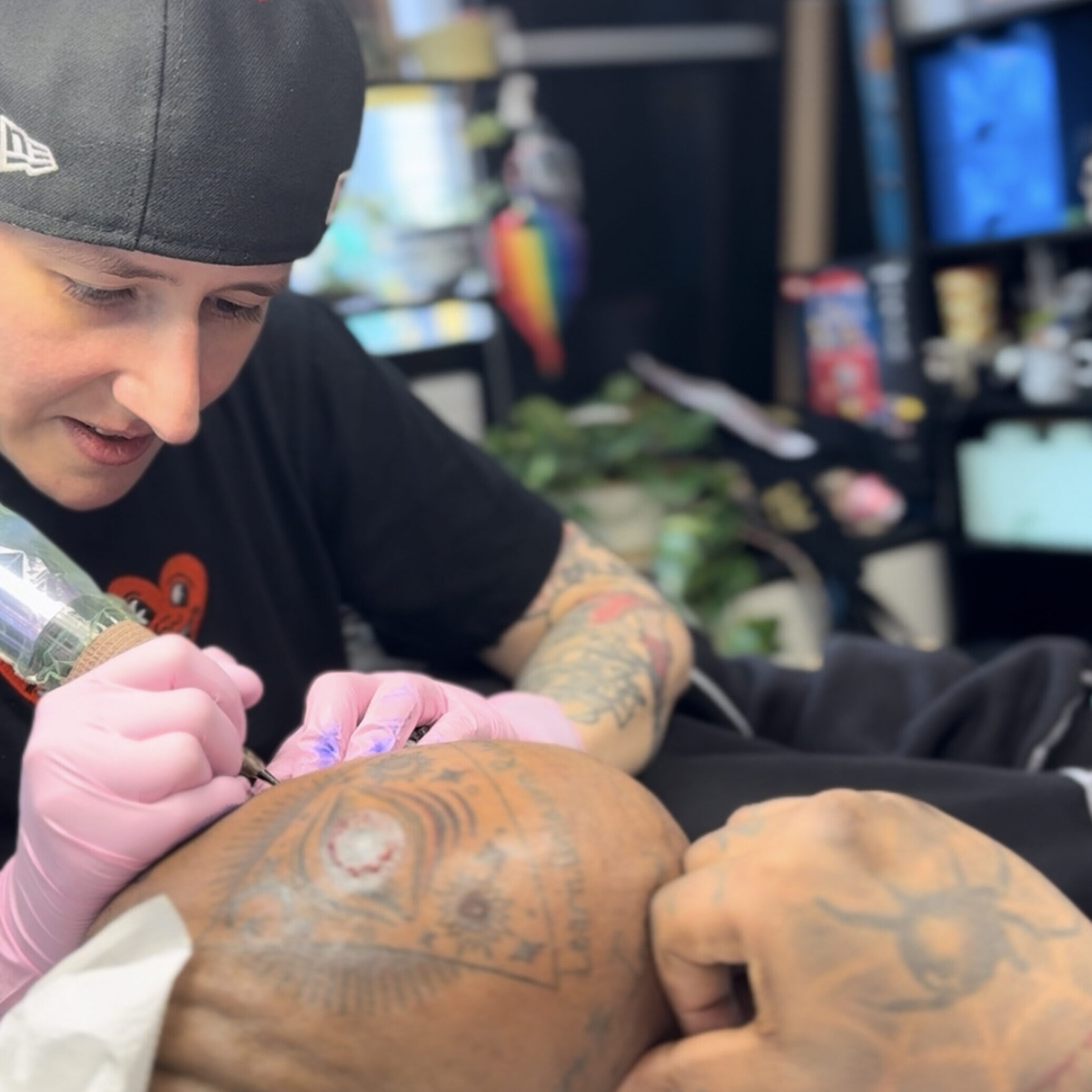 Fineline tattoo artist tattooing a clean line black design on the head of a repeat client in Midtown Manhattan.