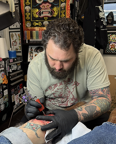 Matt Brodnax tattooing a knee at Red Rocket Tattoo in Manhattan